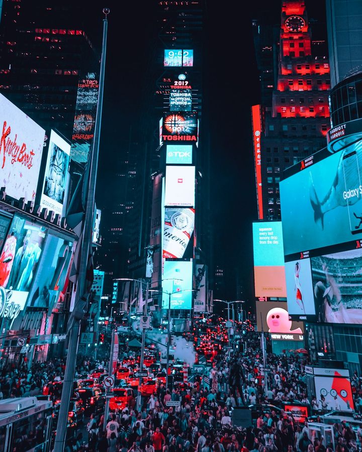 Times Square at night, every building covered in glowing billboards.