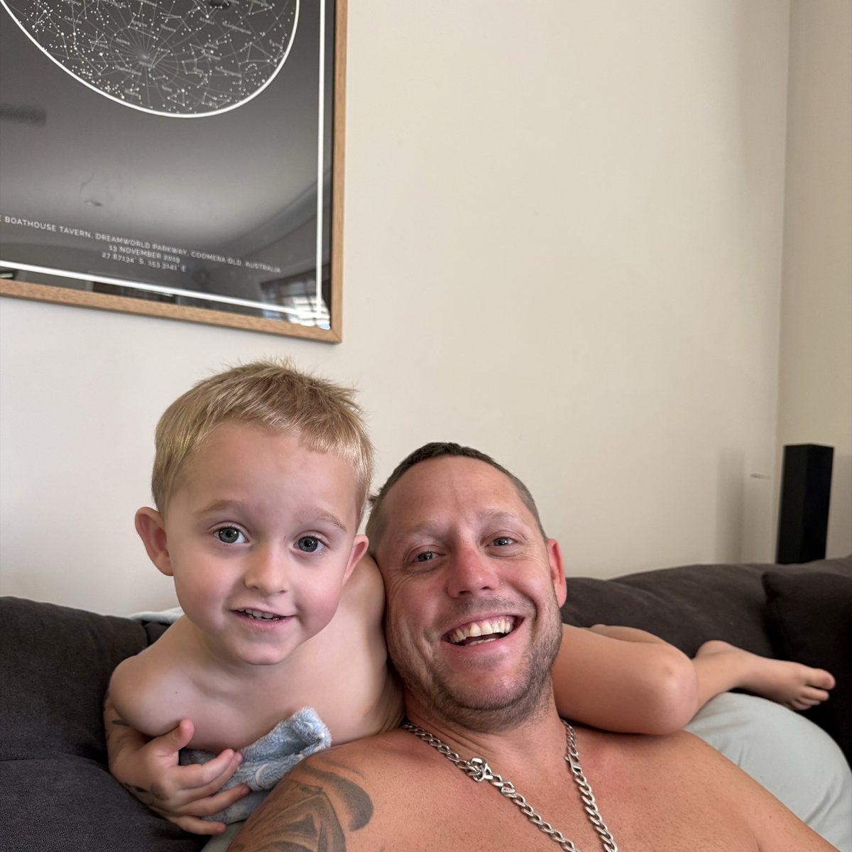 Adam Carberry at home on the couch with his young son.