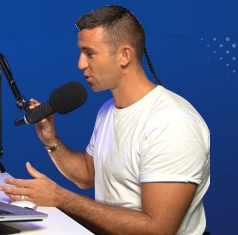Mitch speaking into a studio microphone, mid-conversation.